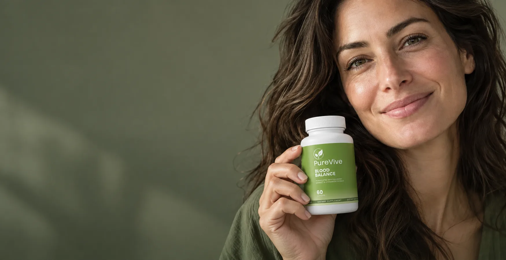 A woman in an olive top holding a bottle of PureVive Blood Balance